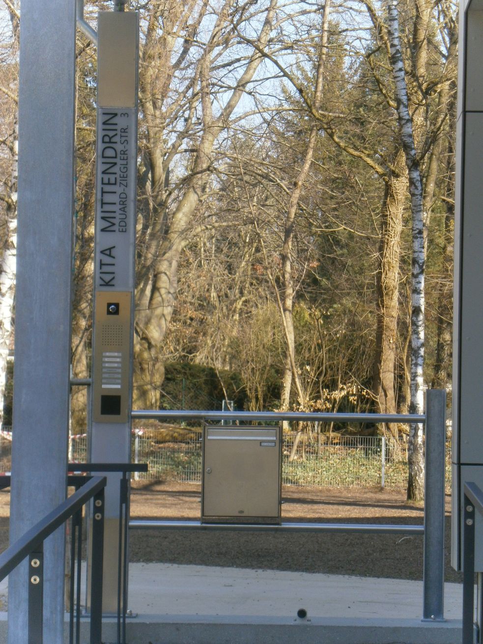Eingang mit Klingelschild und Aufschrift Kita Mittendrin Eduard Ziegler Straße 3