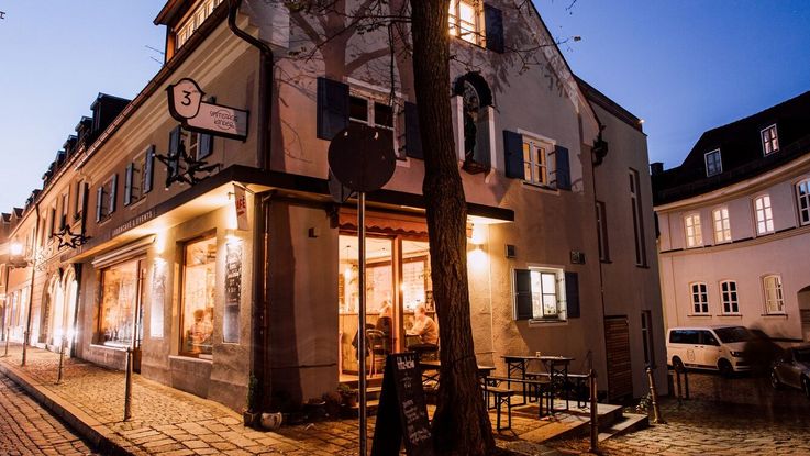 Ein Café in der Dachauer Altstadt, beleuchtet zur blauen Stunde