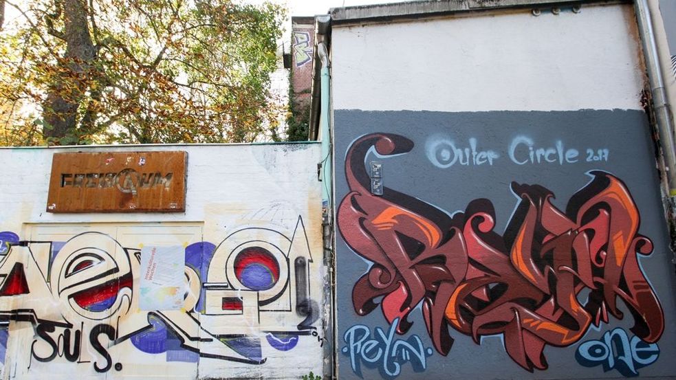 Graffitibespraytes Gebäude mit Metallschild mit Aufschrift Freiraum