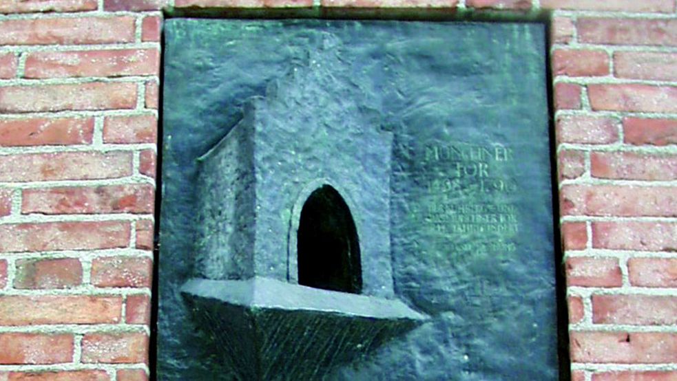 Münchner Tor, Nachbildung von Stephen Lander, Bronze, eingebettet in rote Mauer am Karlsberg Dachau
