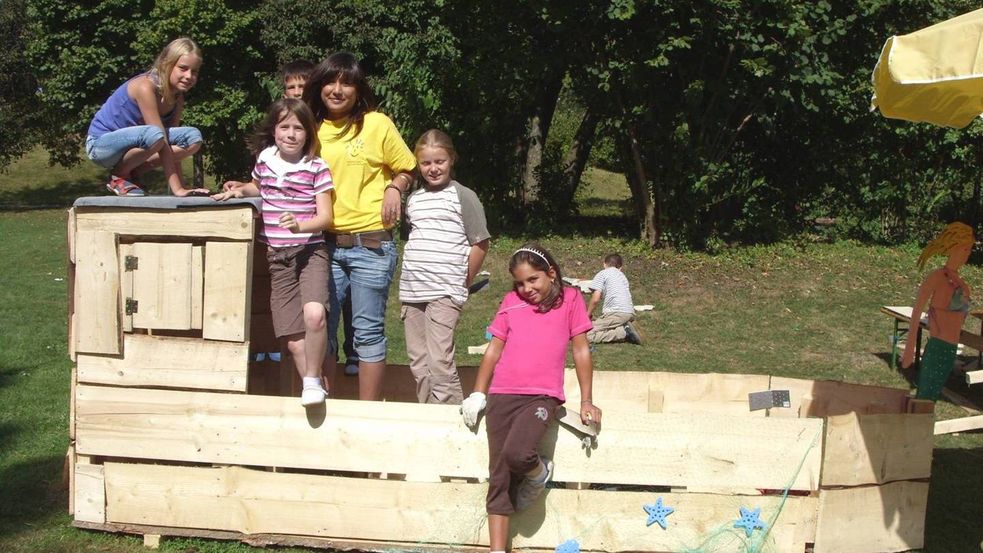 Kinder im selbstgebauten Boot aus Holz