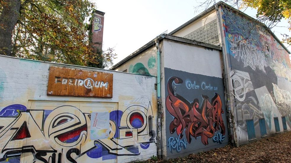 Graffitibespraytes Gebäude mit Metallschild mit Aufschrift Freiraum