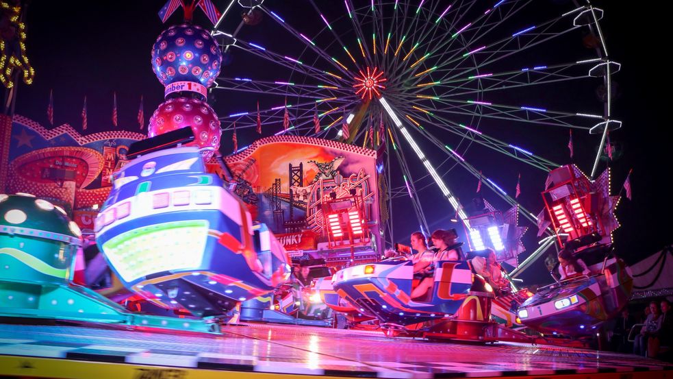 Photo of Dachau Country Fair at night: colorful lights of carousels and huts at night. Photo: City of Dachau