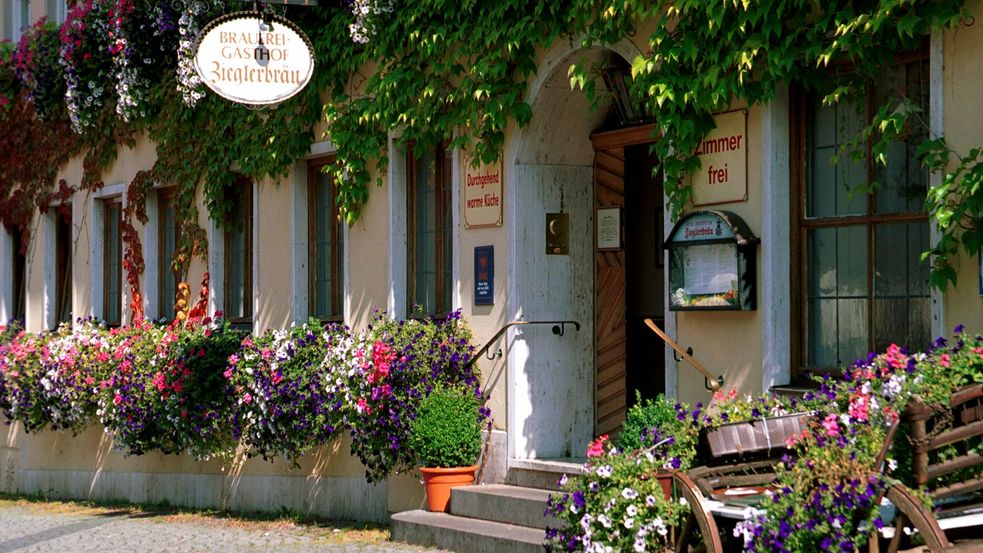 Fassade des Altstadthotels Zieglerbräu mit blühenden Blumenkästen und Eingangstür