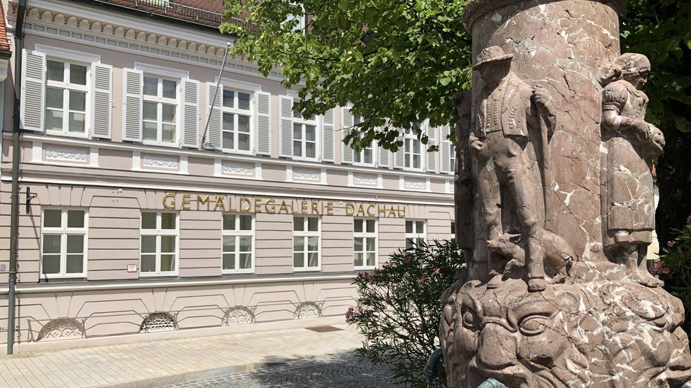 Gebäude der Gemäldegalerie Dachau von Außen, rechts im Bild ein Teil des Taschner Brunnens