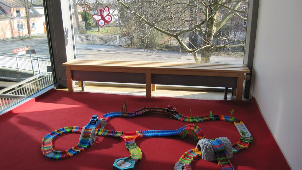 Spielecke mit Spielbahn und Fensterfront mit Blick nach draußen