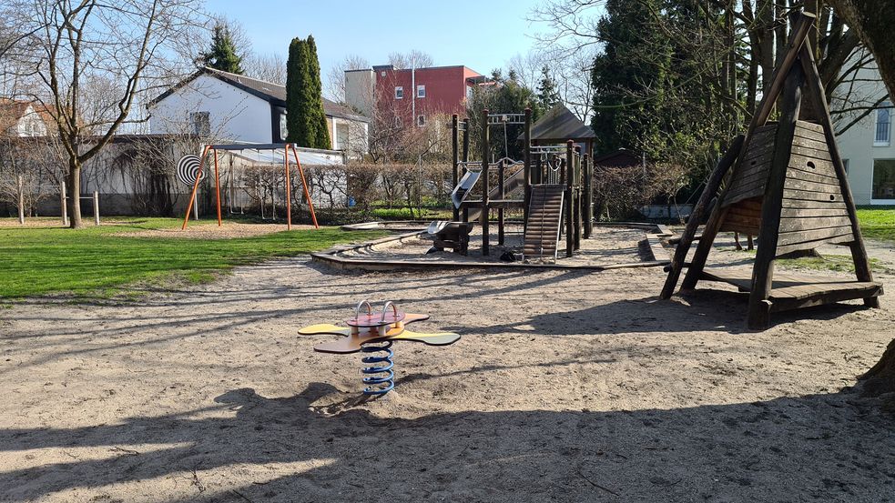 Spielplatz mit Holzturm-Rutsche, Wippe und Schaukel