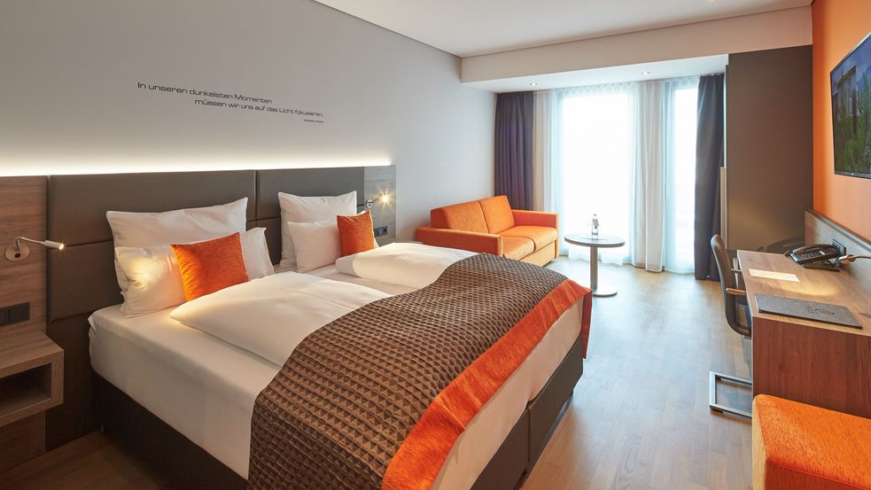 Doppelzimmer im Hotel Modi. Einrichtung in den Farben Orange und braun gehalten.