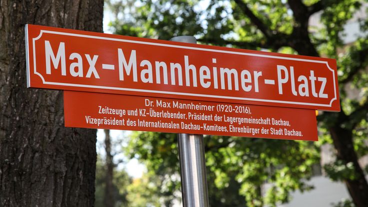 Straßenschild Max-Mannheimer-Platz in Dachau, darunter ein Tafel mit Erläuterungen zur Person Max MAnnheimer
