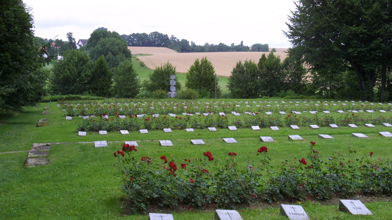 tomb slabs on a grass field surounded by trees