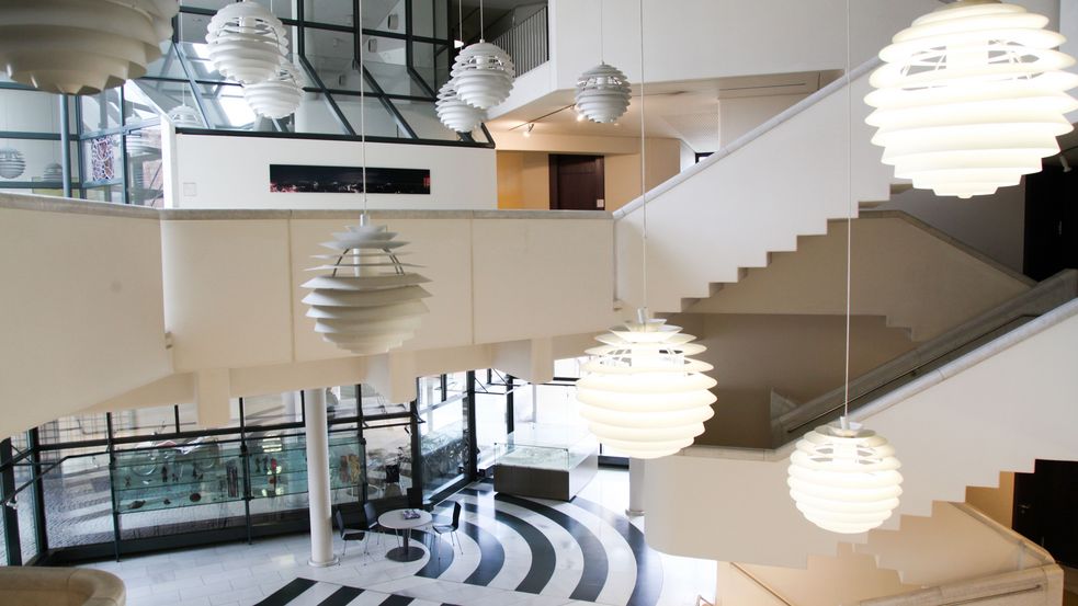 Photo of Dachau town hall foyer with lit up hanging lights and black and white marbele floor pattens. Photo: City of Dachau