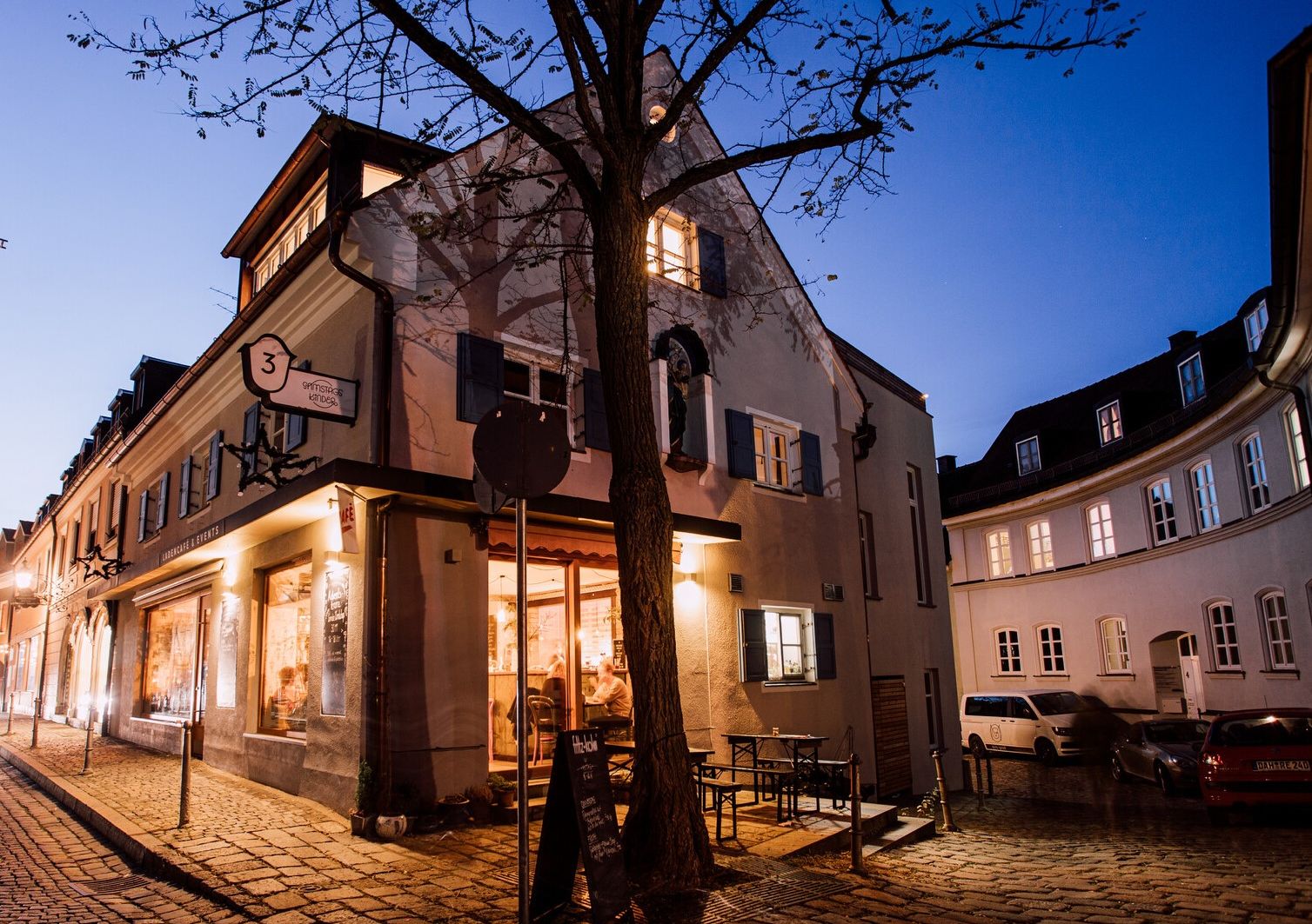 Ein Café in der Dachauer Altstadt, beleuchtet zur blauen Stunde