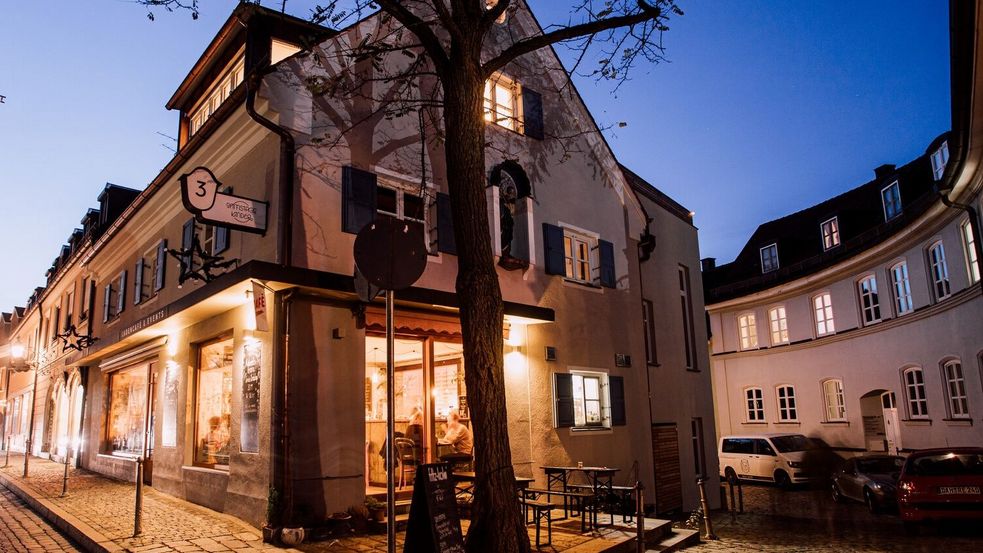 Ein Café in der Dachauer Altstadt, beleuchtet zur blauen Stunde