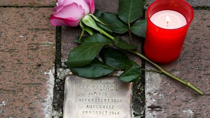 2 Stolpersteine von Max Wallach und Melitta Wallach verlegt in Dachau, mit liegender roter Rose und Kerze