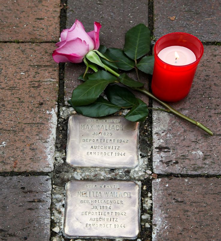 Photo of 3 of sculptor Gunter Demning’s stolpersteine or stumbling stones in Dachau with red tulip, photo: City of Dachau