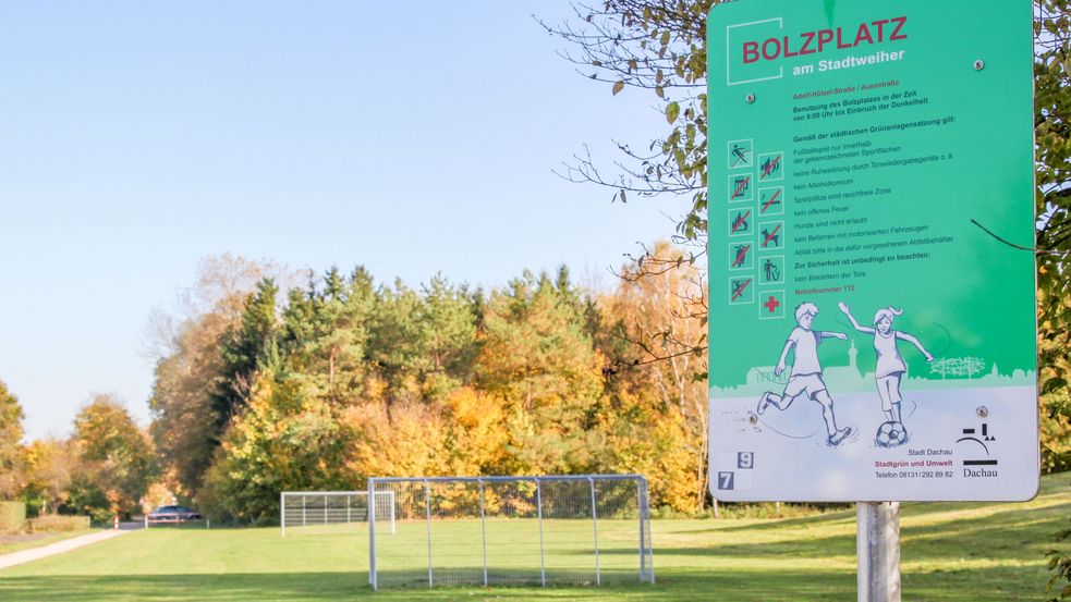 Bolzplatzregelschild und Bolzplatz im Hintergrund