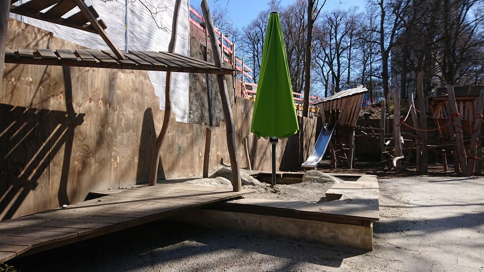 Kleiner Spielplatz mit Rutche und Sonnenschirm