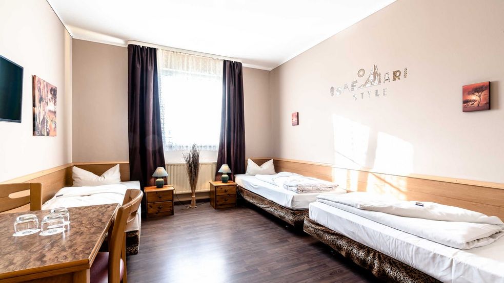 Foto von Zimmer im Ba­va­ria Sa­fa­ri Hotel, an der rechten Wand stehen zwei Einzelbetten