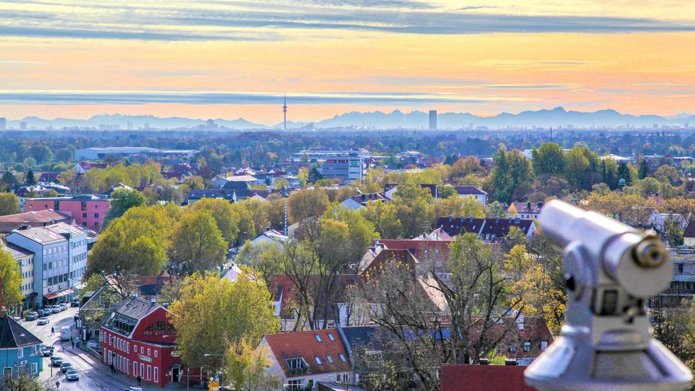 Ausblick auf Stadt Dachau mit vielen Bäumen und Alpenpanorama am Horizont