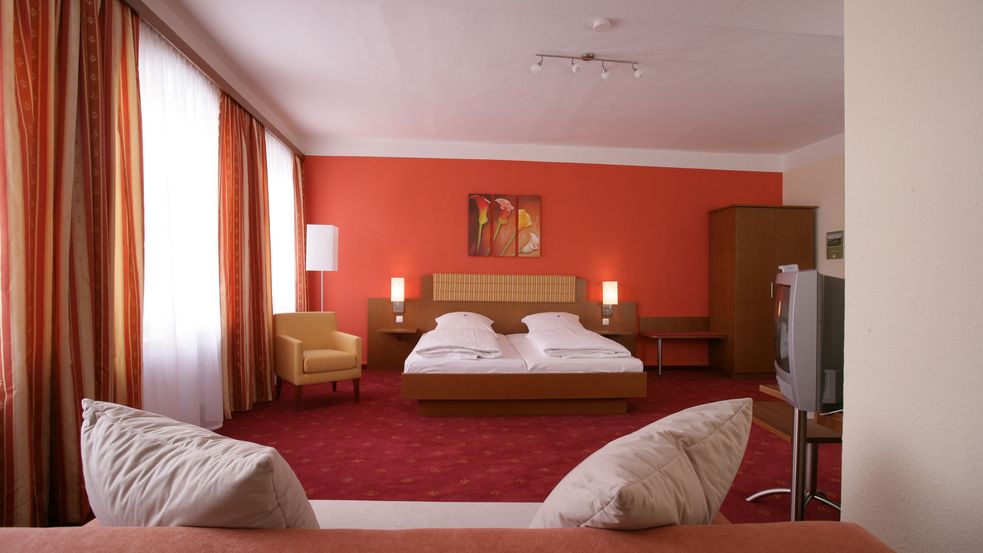 Doppelzimmer im Altstadthotel Ziegler in Dachau, Blick von einer Couch auf das Doppelbett