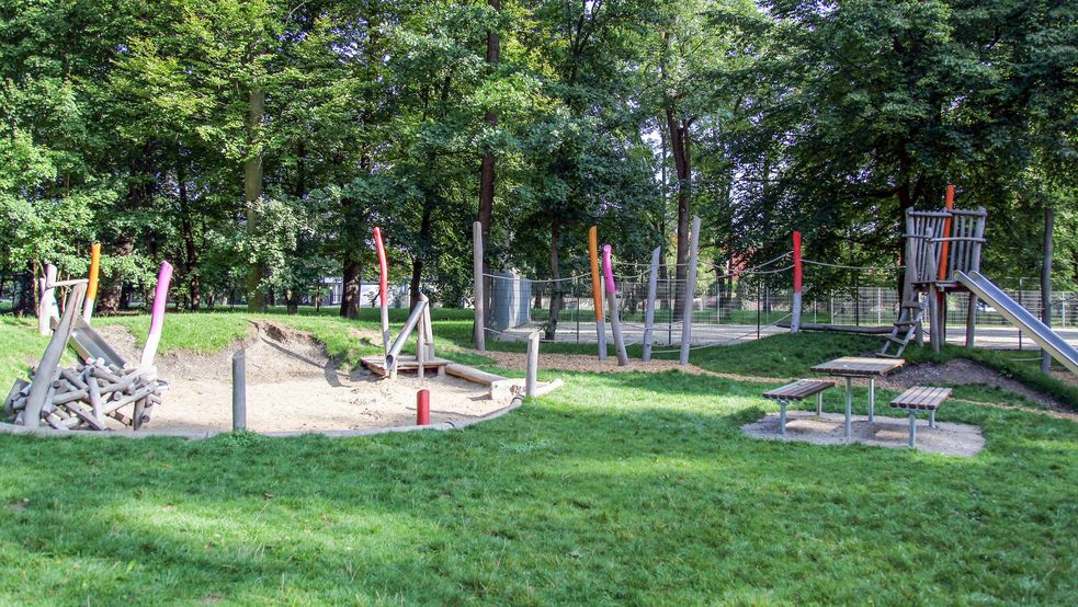 Rutschen Kletterparcours und Tisch mit Bänken umgeben von Wiese