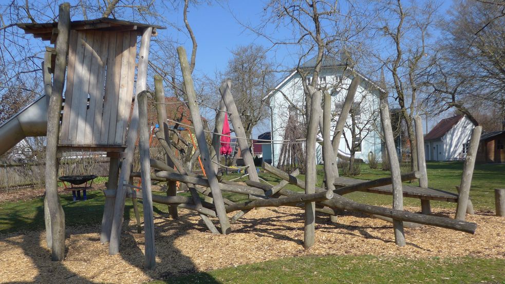 Spielplatz mit Holzturm, Rutsche und Kletterparcour aus Holz