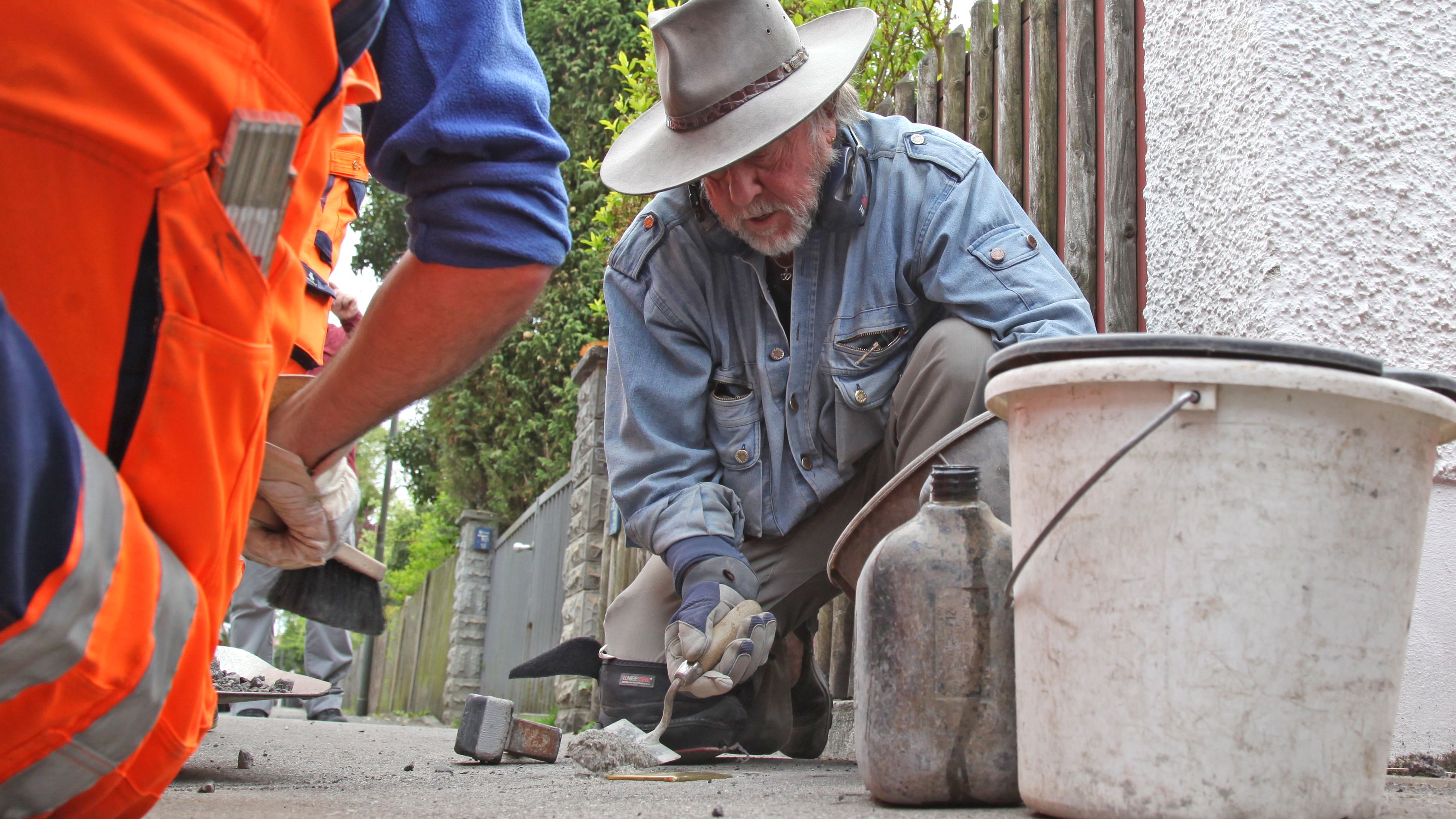 Künstler Gunter Demnig bei der Verlegung eines Stolpersteins in Dachau,