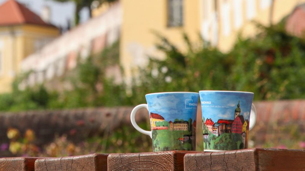 Photos of cups with colourful art print in front of the castle wall, Dachau Castle