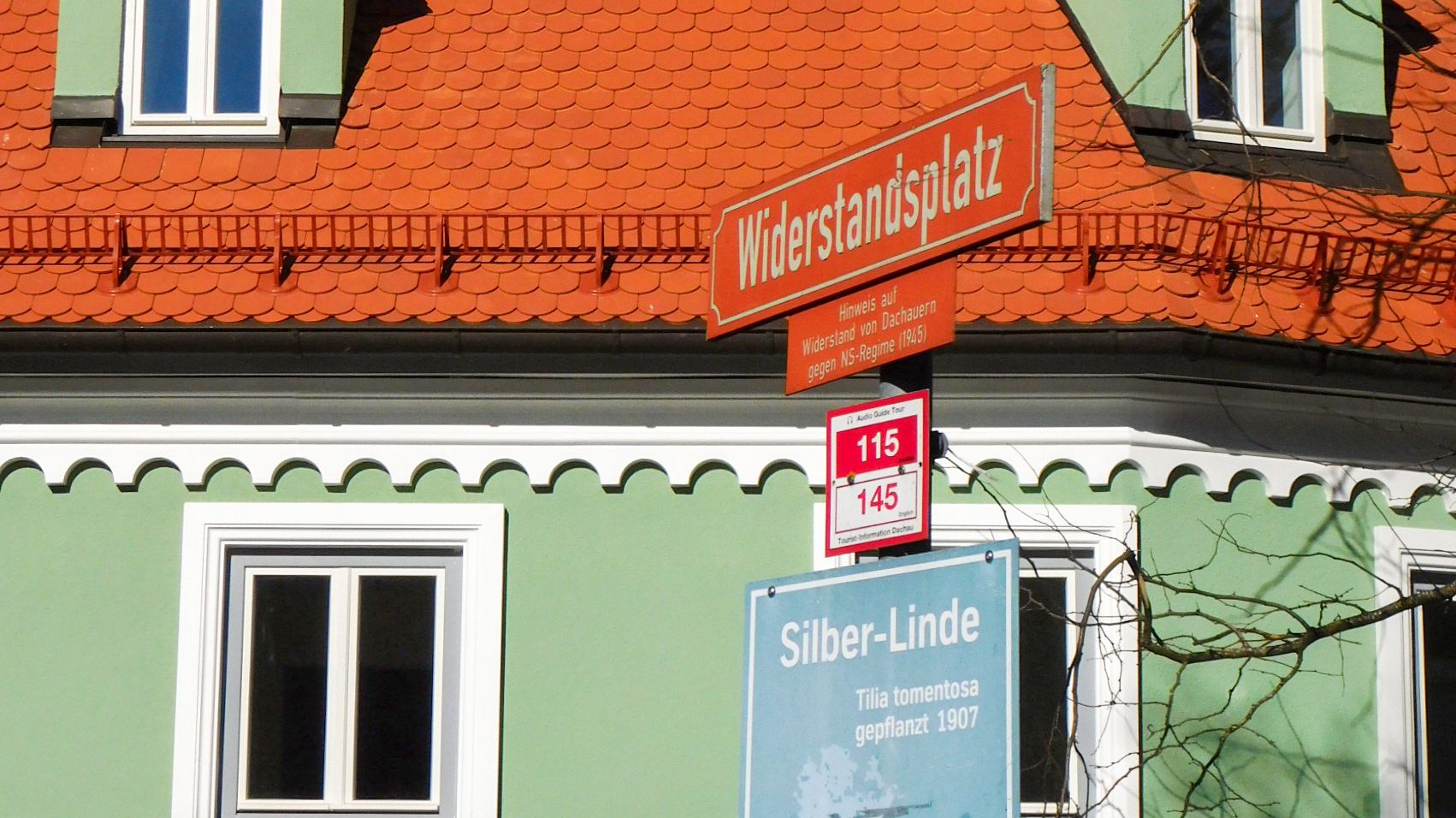 Grünes Haus am Widerstandsplatz in Dachau, Straßenschild im Vordergrund Grünes Haus am Widerstandsplatz in Dachau, Straßenschild im Vordergrund