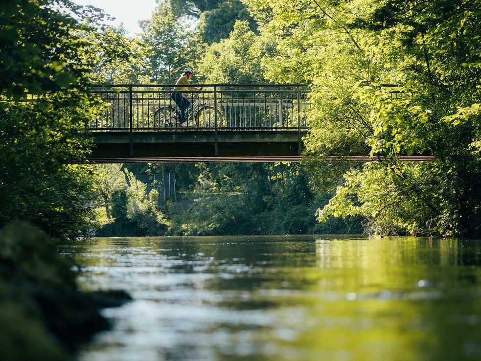 Amper in Dachau, links im Bild verläuft ein Radweg, rechts im Bild eine kleine Fähre über den Fluss