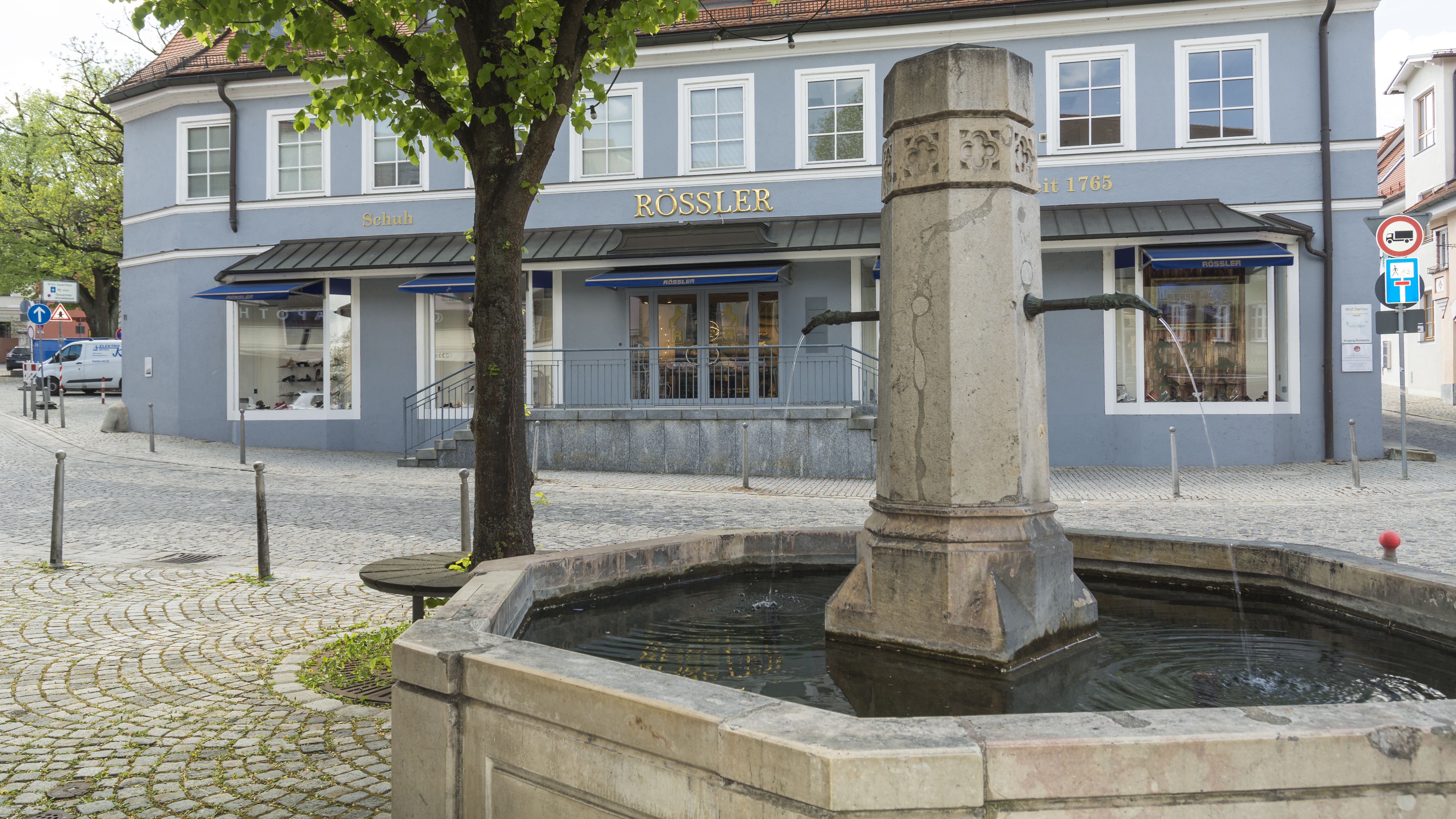 Roßmarktbrunnen in Dachau, dahinter blaues Gebäude "Schuh Rößler"