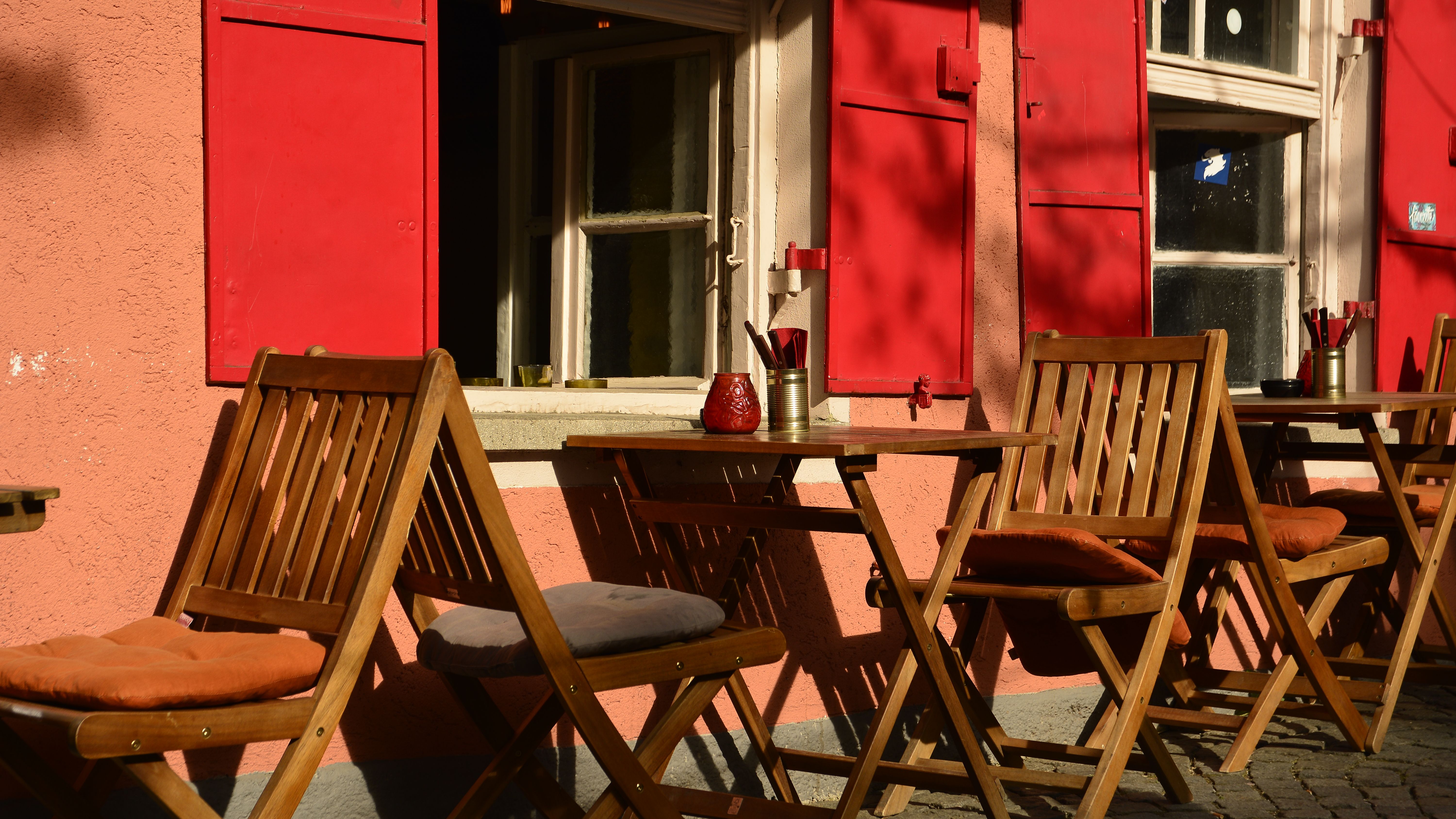 Foto von Gastronomiebetrieb mit Außenbestuhlung in Dachau, rote Fensterläden