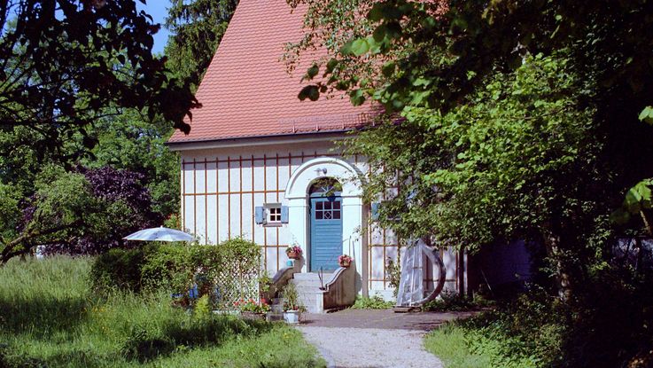 Künstlerhaus Carl Thiemann, kleines Haus mit blauer Tür, in großem Garten.