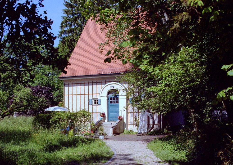 Künstlerhaus Carl Thiemann, kleines Haus mit blauer Tür, in großem Garten.