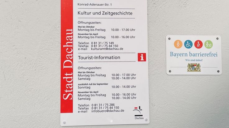 Schilder zur Barrierefreiheit und den Öffnungszeiten an der Tourist-Information in Dachau