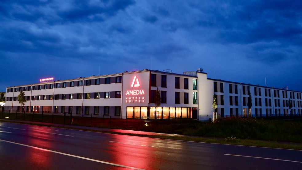 Außenansicht des Amedia Hotels & Suites in Dachau bei Nacht