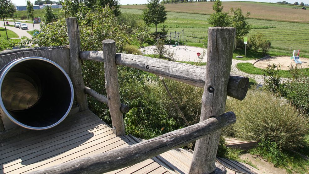 Einstieg der Röhrenrutsche mit Blick auf Spielplatz und grüne Umgebung