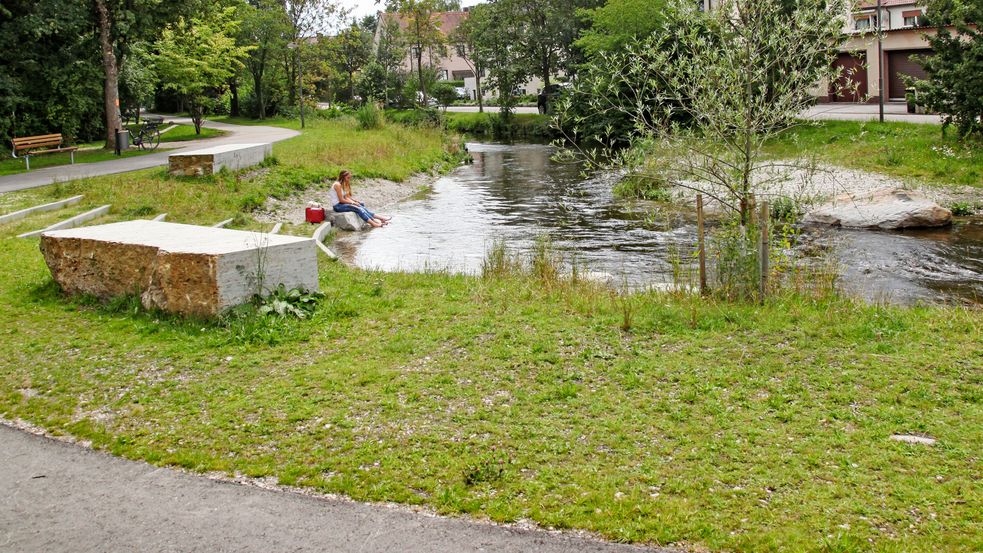 Renaturated Würm river in Dachau with stone benches and green sitting. Photo: City of Dachau