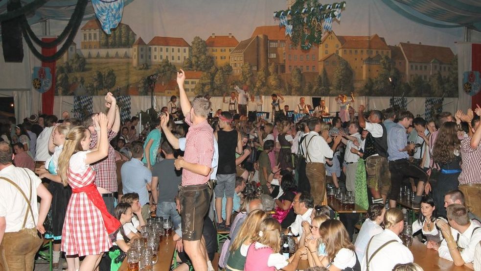 people dancing and singing in the beer tent