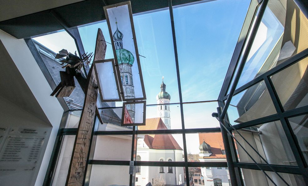 Blick durch die Fenster des Dachauer Rathauses auf Kirchturm von St. Jakob mit Glasmalerei