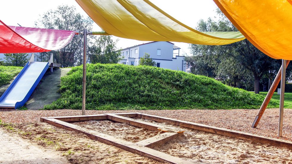 Mehrere Sonnensegel darunter ein Sandkasten und im Hintergrund eine Rutsche