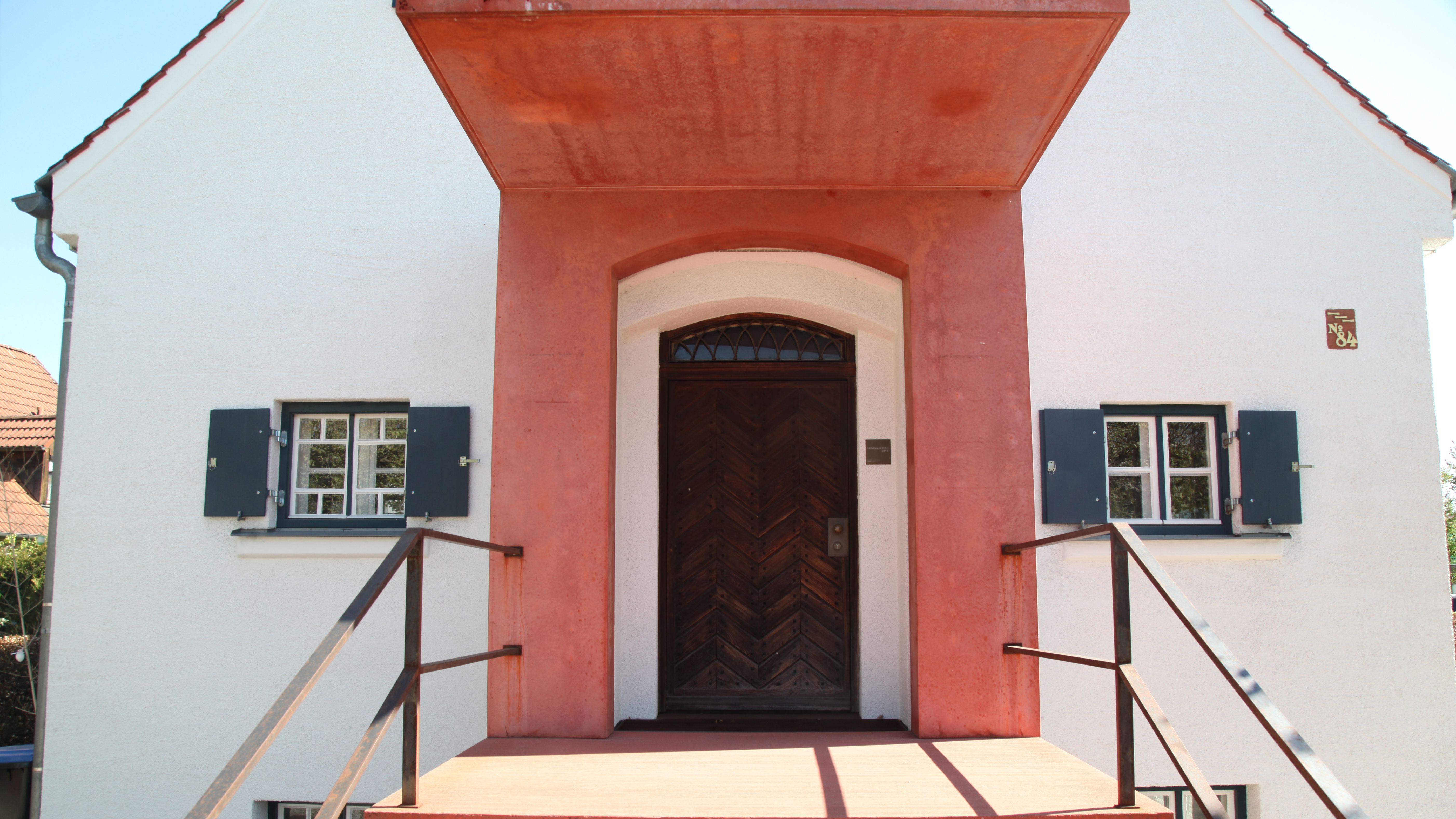 Vorderansicht der Ruckteschell-Villa mit rotem Treppen- und Eingangsbereich der Villa