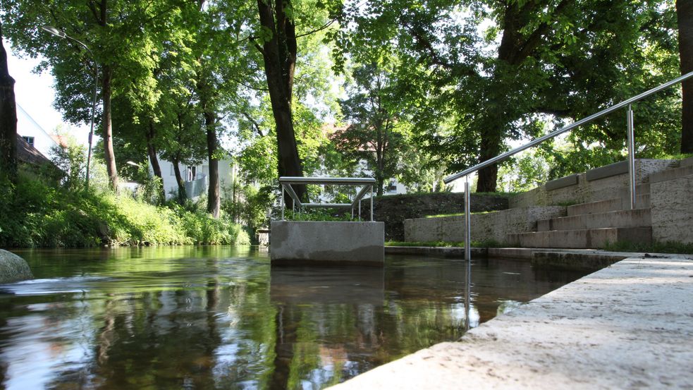 Wassertretanlage im Moorbad-Park, Fotografie auf Höhe des Wasserspiegels des Ascherbachs, die Bäume spiegeln sich in der Wasseroberfläche