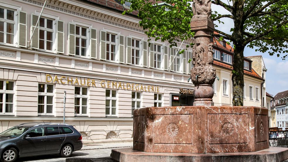 Steinbrunnen mit Figur vorm Eingang zur Galerie