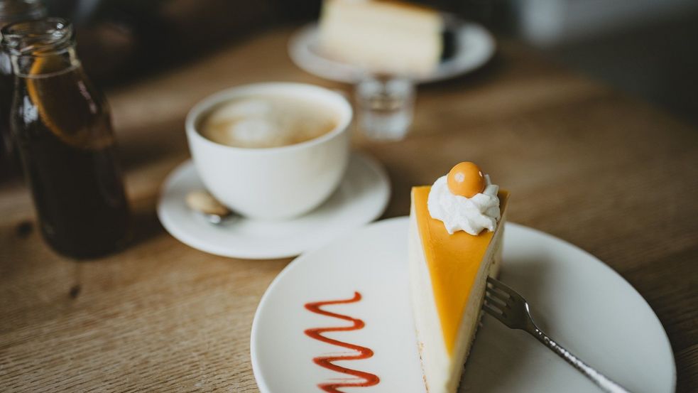 Café und Tortenstück auf einem Tisch angerichtet