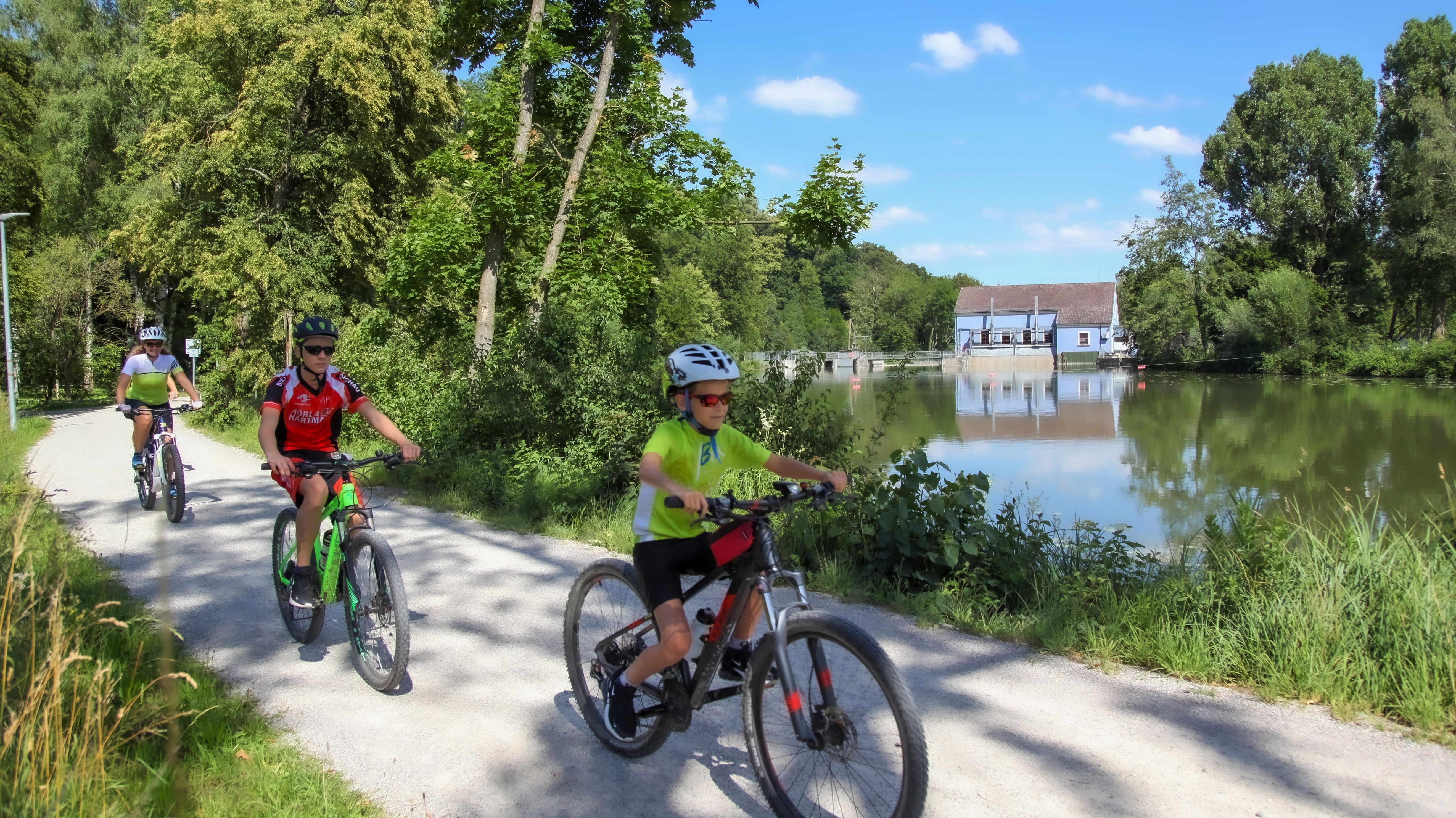 sportliche Familie auf Fahrrädern an der Amper