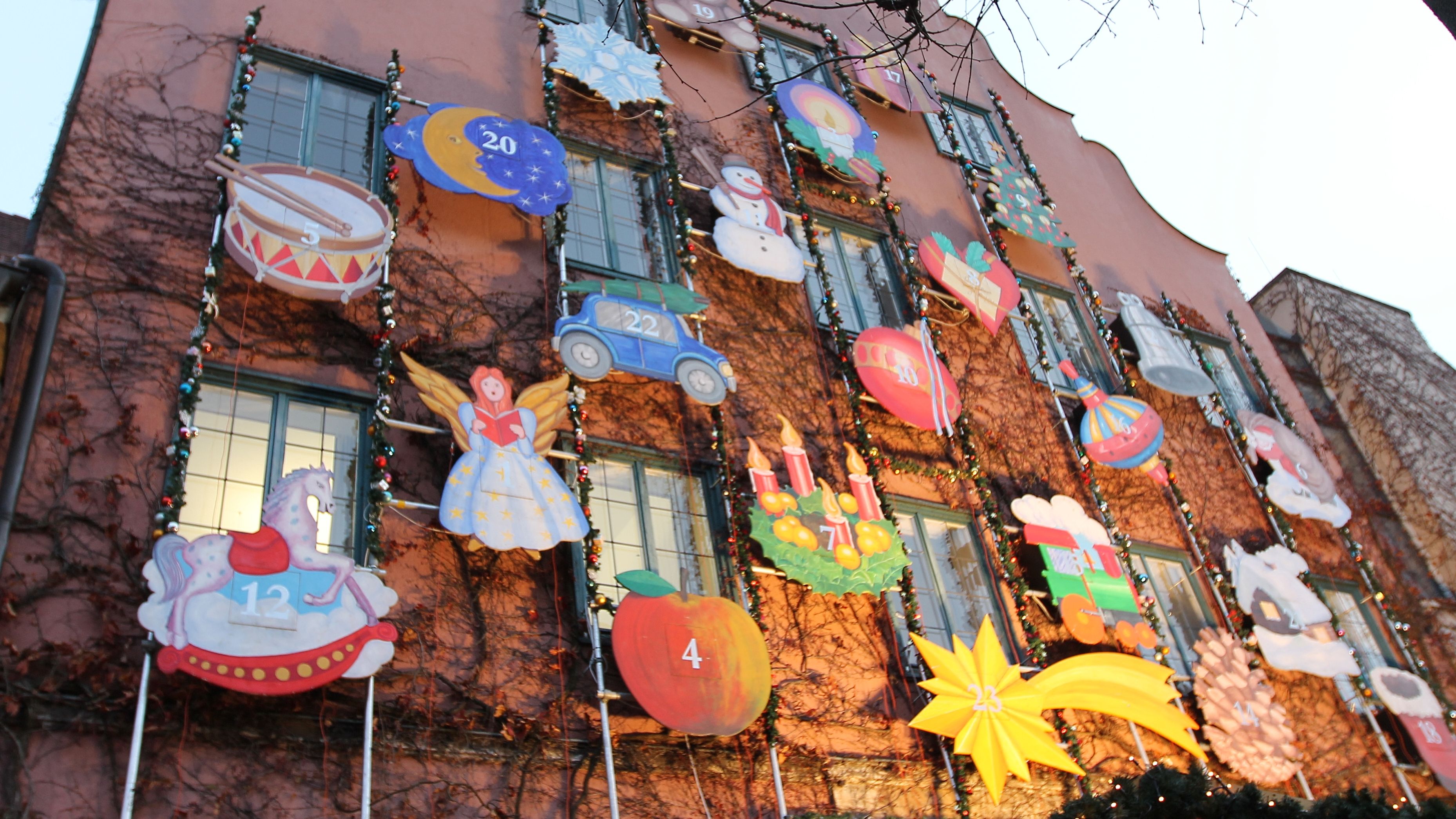 Adventskalender an der Rathausfassade mit vielen Weihnachtsmotiven wie Engeln und Sternen