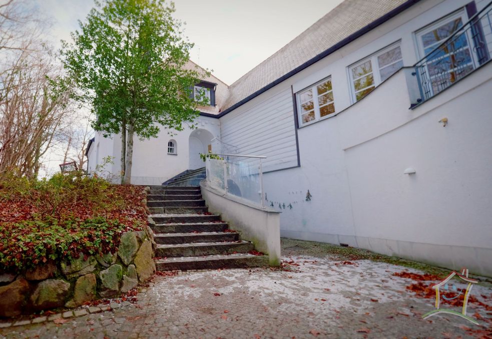 Feldbauer Villa in Dachau Mitterndorf, eine Treppe führt zur Haustür, rechts eine Mauer mit kleiner Terrasse