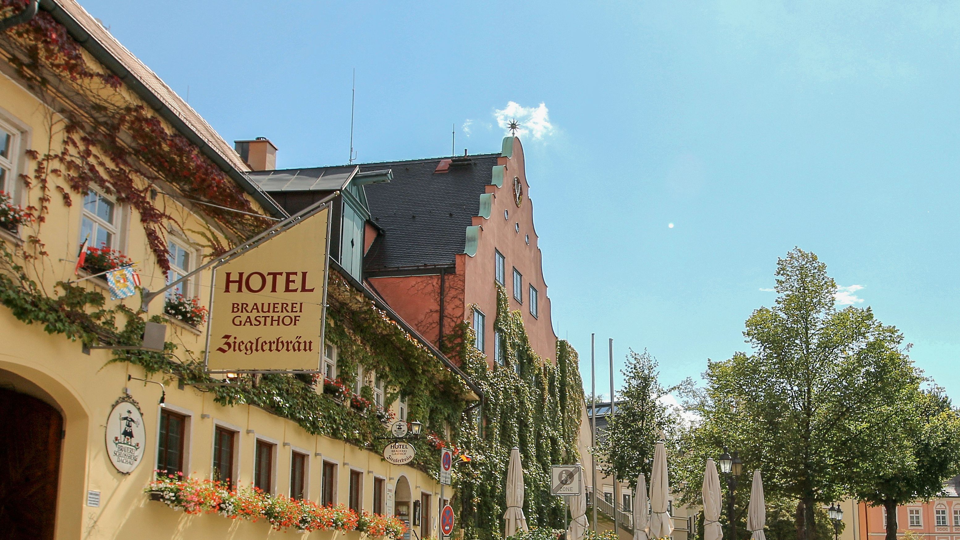 Gelbe Außenfassade des Hotel Gasthof Ziegler mit Außensitzbereich