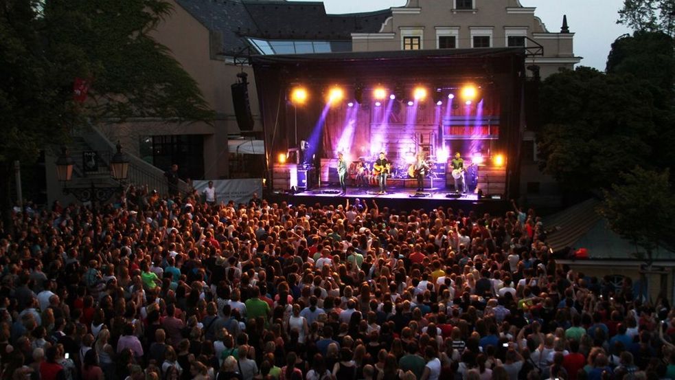 Openair Konzert mit vielen Zuschauern und hell beleuchteter Bühne